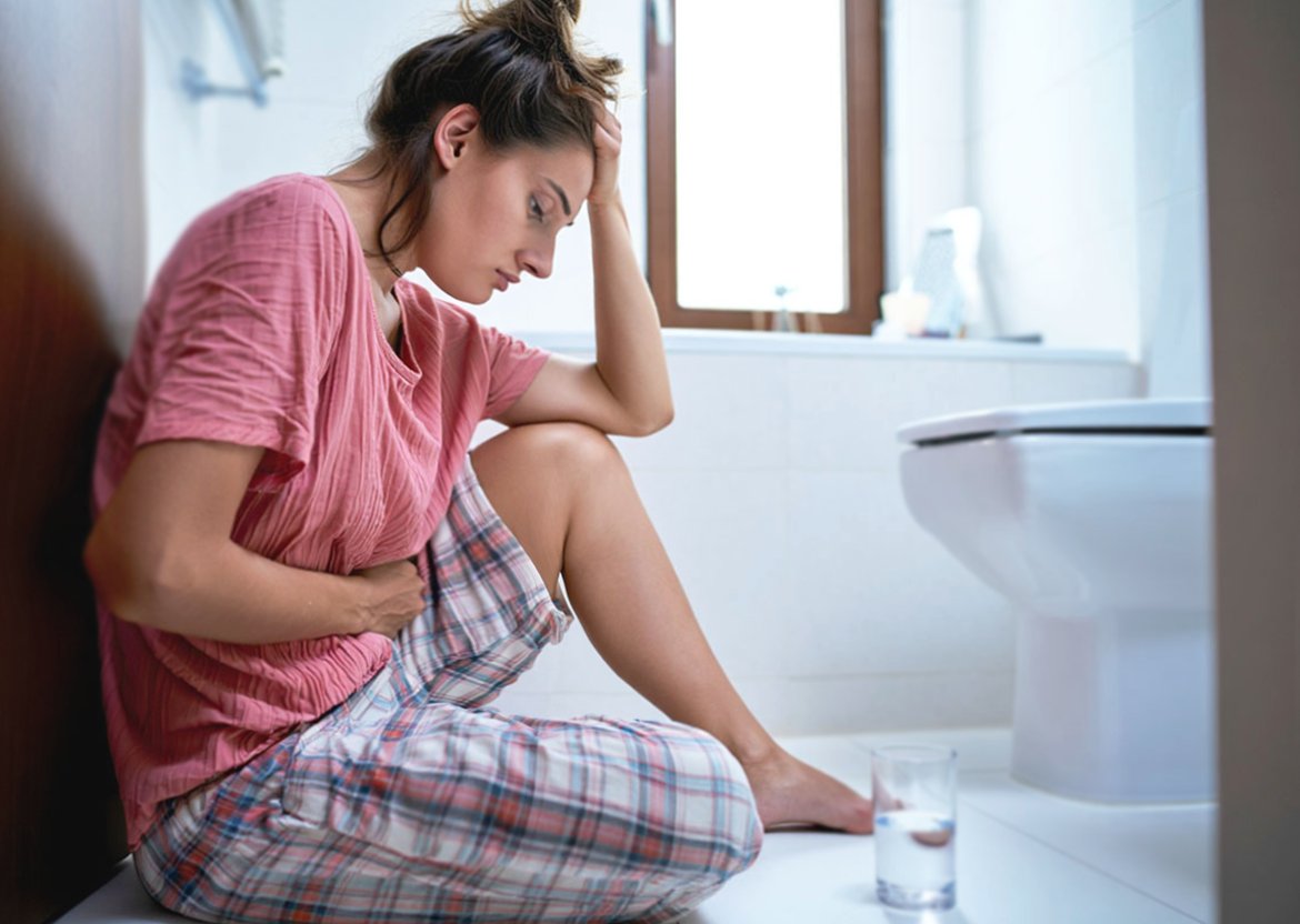 /Девушка грустно сидит над тарелкой еды